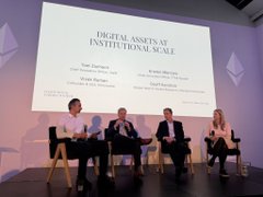 A panel discussion titled "Digital Assets at Institutional Scale" featuring four speakers seated on stage with their names and titles displayed on a large screen behind them.