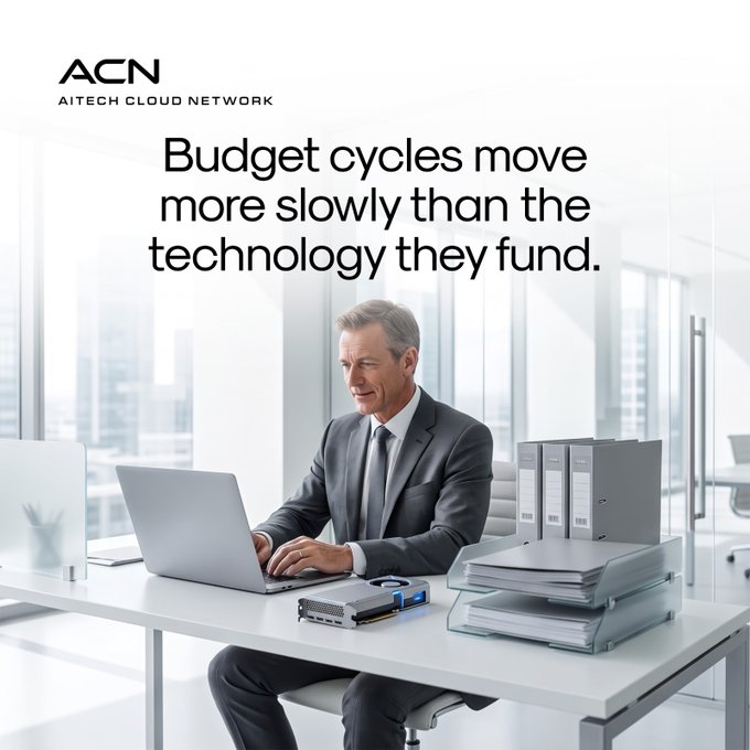 A businessman in a gray suit works at a modern office desk with a laptop, binders, and papers, with the ACN (AI Tech Cloud Network) logo and the headline "Budget cycles move more slowly than the technology they fund" displayed above. The image visually reinforces the post's message by depicting a finance or IT professional immersed in traditional planning tools, symbolizing how outdated budget cycles struggle to keep pace with rapidly evolving AI infrastructure.