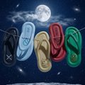 A collection of colorful Crocs-style shoes in black, blue, gold, red, and green displayed against a dark blue background with a full moon and stars.