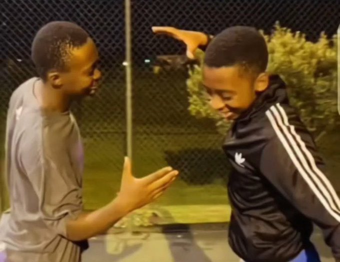 Two young boys share a joyful moment, smiling at each other with one raising his hand above his head in a playful gesture. The image likely relates to the giveaway post by showcasing a candid, lighthearted scene that evokes positivity and connection, fitting the celebratory tone of the contest announcement.