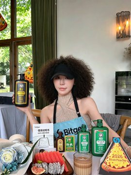 iced tea, pizza, and a bottle of wine are displayed on a table with a woman holding a book titled "Bitege" above them.