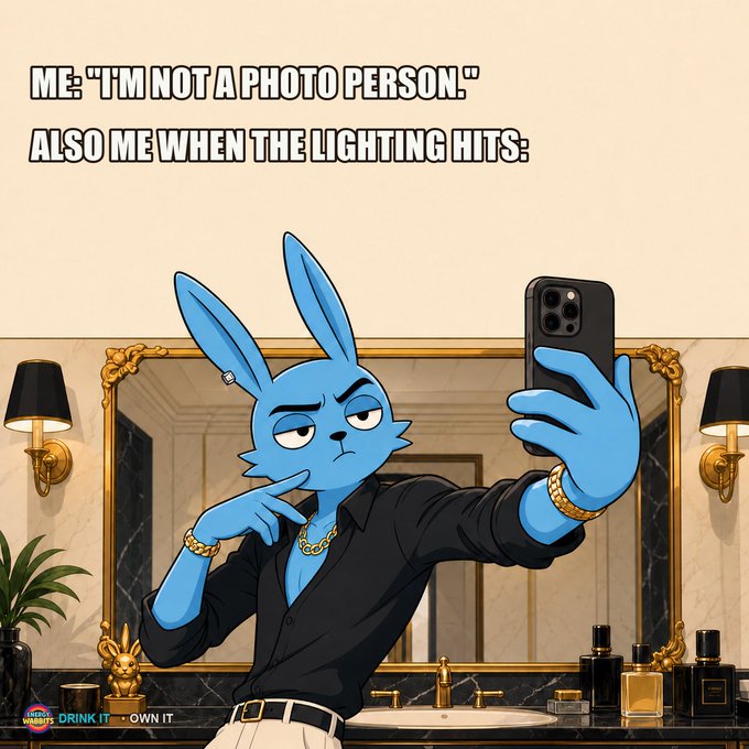 A humorous cartoon of a blue rabbit taking a confident selfie in a fancy bathroom mirror, captioned 'ME: "I'M NOT A PHOTO PERSON." ALSO ME WHEN THE LIGHTING HITS:' with a watermark 'DRINK IT - OWN IT'.