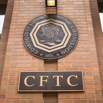 The image shows the CFTC seal mounted on a brick wall, with "Commodity Futures Trading Commission" inscribed around an eagle emblem and "1975" below, along with a placard displaying the acronym "CFTC." The image directly relates to the post by visually identifying the agency at the center of the news that the Commodity Futures Trading Commission is advancing new crypto market structure rules under Chair Michael Selig.