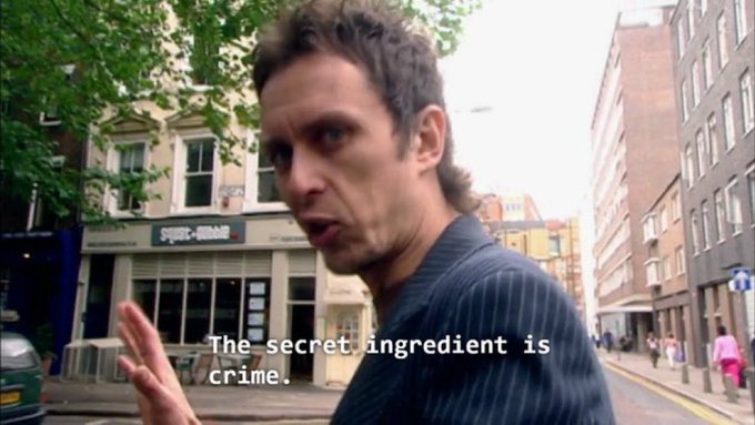 A man on a city street looking at the camera with the subtitle 'The secret ingredient is crime.', a famous quote from the TV show 'It's Always Sunny in Philadelphia'.
