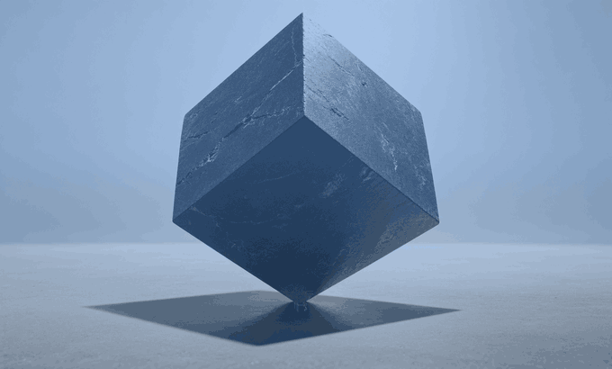 A dark blue cube balancing on one of its corners on a small point against a light blue background, casting a square shadow.