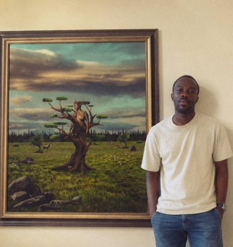 A man standing next to a framed surrealist painting of an African savanna featuring a unique tree with flat, disc-shaped canopies.