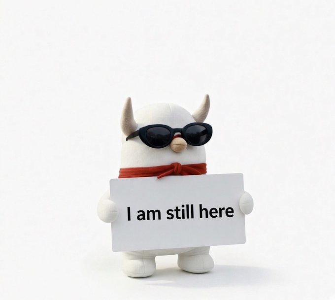A plush penguin-like character wearing black sunglasses and a red scarf holds a white sign reading “I am still here.” The image visually reinforces the post’s “WE ARE STILL HERE” message, alongside the listed cryptocurrency tickers.