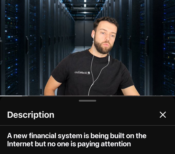 A man with a beard wearing earphones stands in a server room, with a description overlay reading 'A new financial system is being built on the Internet but no one is paying attention.'