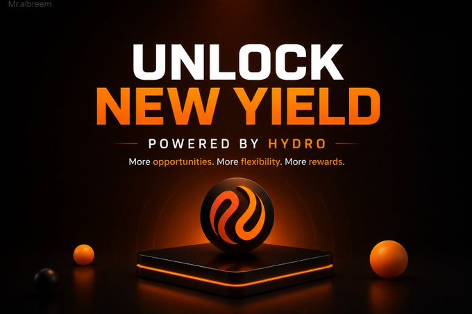 The image features an advertisement for a cryptocurrency called @hydro_fi, which is powered by @injective's Multi-VM infrastructure. The text on the image reads "Unlock New Yield" and "Powered by Hydro". The background of the image is black with orange balls scattered around it. The main focus of the image is an orange ball placed in a square base that has the words "hydro" written on it, indicating that this is related to the hydro-fi cryptocurrency.