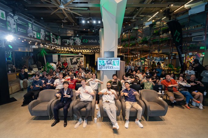 A large group of people pose together with "SUPERTEAM" and "metaplex" displayed on screen, capturing a collaborative gathering between global infrastructure teams and local leaders in Thailand.
