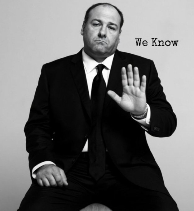 A black-and-white photo of a man in a suit making a stop gesture, accompanied by the text "We Know".