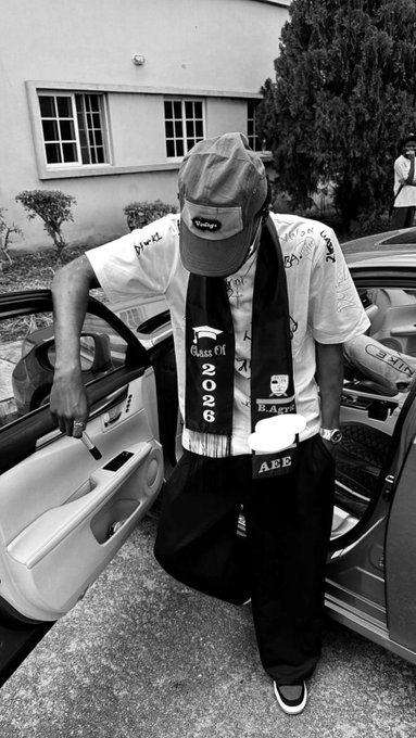 A young man steps out of a luxury car wearing a graduation sash reading "Class Of 2026," matching the celebratory signout vibe of the post as he promotes referral code KARO for the PUEX trading platform with cash giveaways.