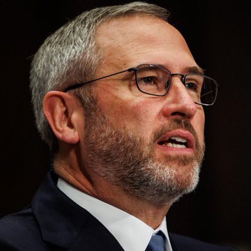 The image features a man wearing glasses, a suit jacket with a tie, and a beard, giving him a professional appearance. He is seated behind a desk or podium, which suggests that he might be giving a speech or presentation related to cryptocurrency, as indicated by the quote from Ripple CEO Brad Garlinghouse in the accompanying post. The statement made by Ripple's chief executive was about an all-time high for $XRP.