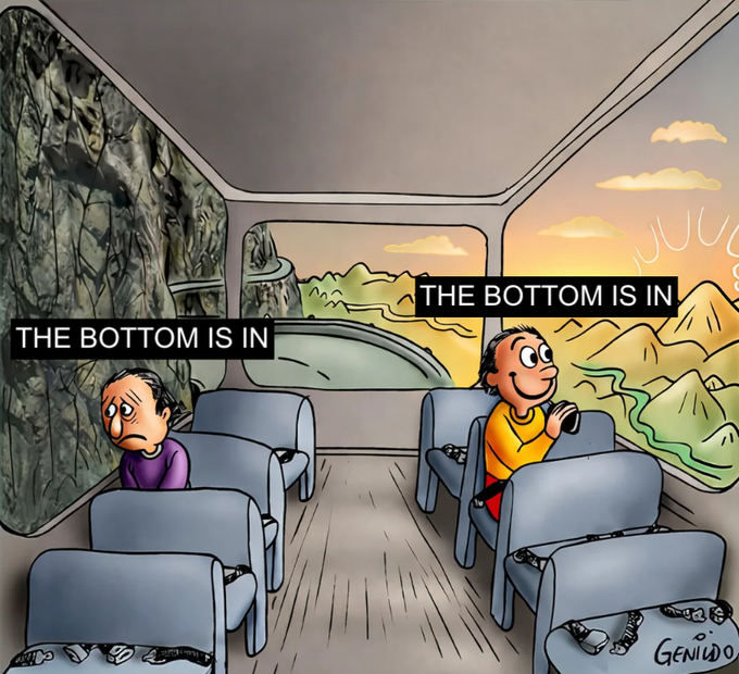 Two passengers ride a bus heading toward a bright, hopeful horizon while the other sits in a dark, rocky cave, both claiming "THE BOTTOM IS IN," illustrating how crypto investors interpret the same market moment through completely opposite lenses of optimism and despair.