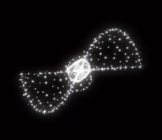A glowing, white dot-style illustration of a bow tie shape with a central circle against a black background.