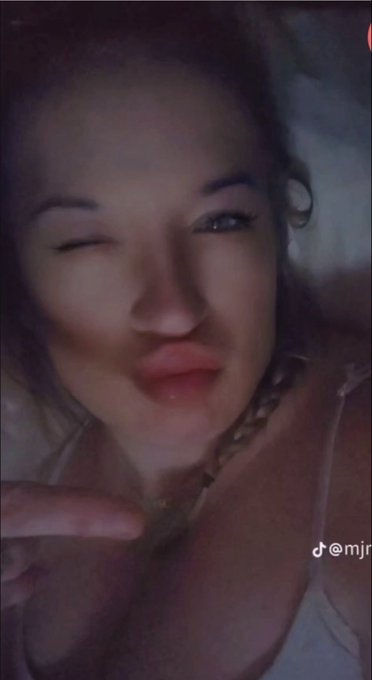 A close-up selfie shows a woman winking and posing with a finger near her face. A partial TikTok handle beginning with “@mjr…” appears on the right, fitting the post’s casual “Gn” (“good night”) message.