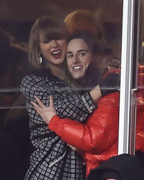 Two women embrace warmly in what appears to be a stadium or arena setting, with one wearing a checkered black and white outfit and the other in a bright red puffy jacket, both smiling broadly. The caption "these are going to 100x on secondary" humorously suggests the social moment or their connection is a hot commodity, likely referencing the enthusiasm of fans treating celebrity sightings as valuable collectibles.