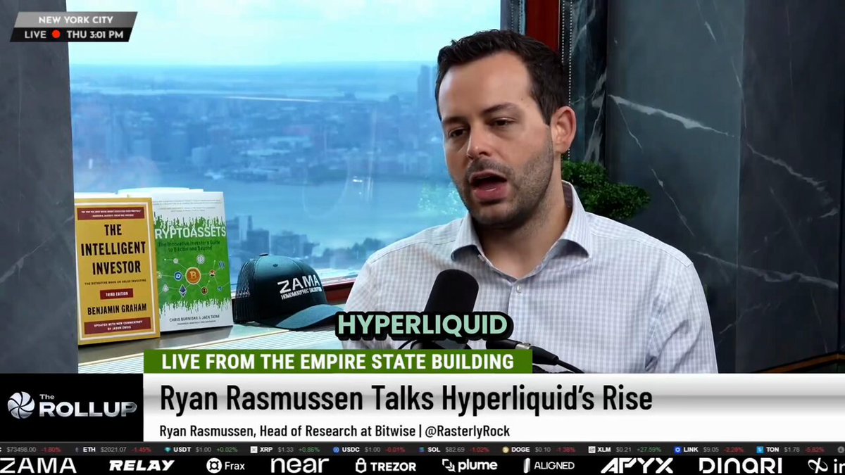 The image features a man sitting at a desk with a TV screen behind him. The TV screen displays an interview with Ryan Rasmussen discussing the concept of HYPE (High Liquidity ETFs) as part of his book, "Live from the Empire State Building". The man is wearing a white shirt and appears to be engaged in conversation about the topic on the show.