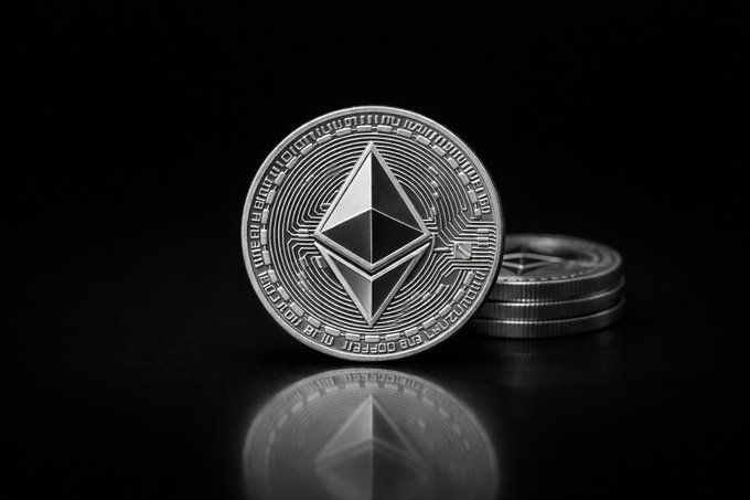 The image features a silver coin with an intricate design, possibly a cryptocurrency symbol, placed on top of two other coins. The coin on the left appears to be slightly larger than the one on the right. The background is black, which makes the coin stand out prominently in the scene. The text "While retail argues over every candle @BitMNR just bought another 26,497 ETH last week Total holdings now: 5.42 million $ETH" suggests that there might have been a recent purchase of cryptocurrency by someone named BitMNR. This could be related to the post about Bitcoin and Ethereum mining, where people are accumulating Bitcoins or Ethers for future transactions.