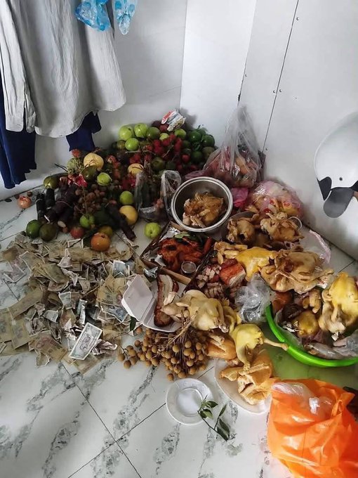 A large pile of offerings—fruits, whole chickens, paper money, and incense—spills across a marble tile floor next to hanging clothes, resembling a traditional Vietnamese ancestor worship altar. The scene humorously contrasts with the caption "Web3 Vietnam bros right now," suggesting crypto traders have gathered abundant ritual offerings to pray for financial relief until month's end.