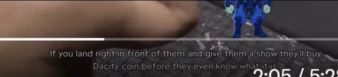 A video game screenshot with subtitles reading 'If you land right in front of them and give them a show they'll buy Dacity coin before they even know what it is' alongside a timer showing 2:05 / 5:25.