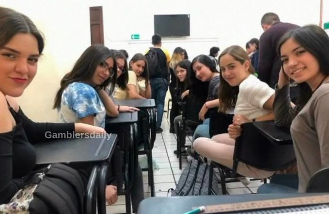 A classroom scene with a group of young women sitting at desks, with a 'Gamblersdaily' watermark on the left side.