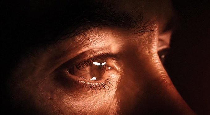 A close-up of an eye reflecting a bright screen in a dark setting, perfectly capturing the regretful stare of someone replaying a past screenshot of a missed trading opportunity instead of having cashed in their profits.