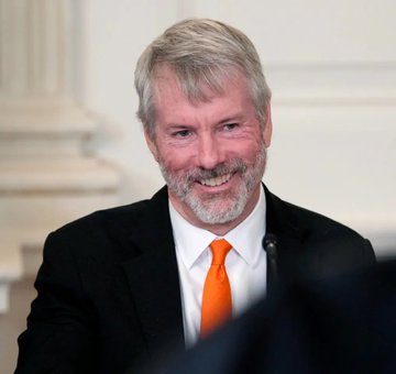 A smiling, gray-bearded man in a dark suit with an orange tie is pictured, likely representing Michael Saylor in connection with the breaking news about his "Strategy Company" selling 3,588 Bitcoin worth $225 million.