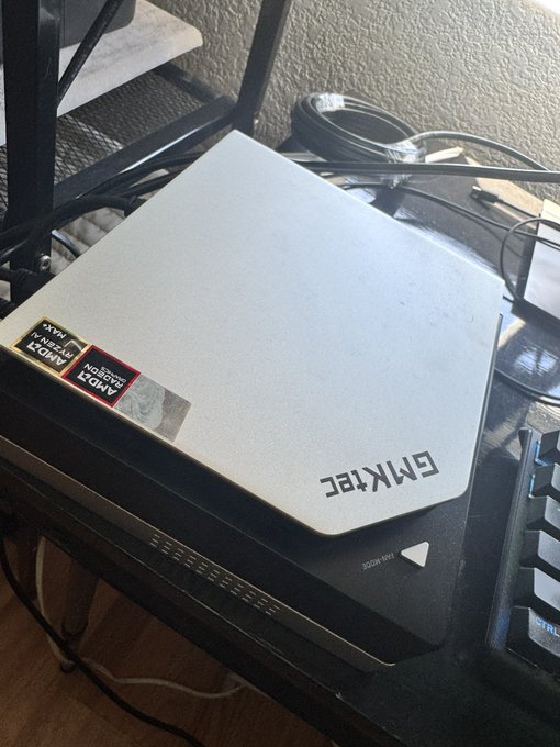 A photograph of an 'EMKTEC' AMD processor box on a desk, rotated upside down.