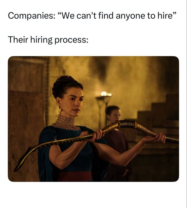 A meme with text 'Companies: "We can't find anyone to hire"' and 'Their hiring process:' above an image of a woman in dark blue attire with a gold neck ring holding a curved, ornate weapon.