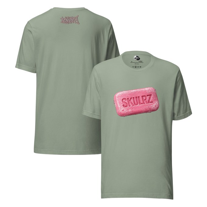 A sage green t-shirt displayed from front and back views, featuring a pink bar of soap graphic with 'SKULRZ' text on the front and a pink logo on the back collar area.