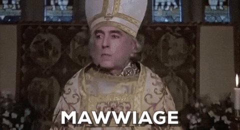 The image features an actor dressed as a king or queen with a white hat and robe, standing next to a candle. The caption reads "maw wiage" above the actor's head, which seems to be a reference to the character they are portraying in the movie.