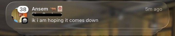 A translucent social media notification bubble showing a user named 'Ansem' posted 'ik i am hoping it comes down' 5 minutes ago, with the username partially redacted.