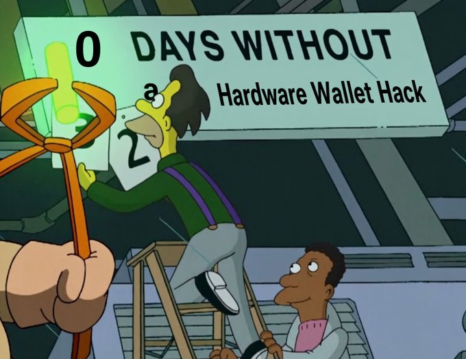 A parody image in the style of The Simpsons showing a character on a ladder adjusting a sign that reads '0 DAYS WITHOUT a Hardware Wallet Hack' under a green glow.
