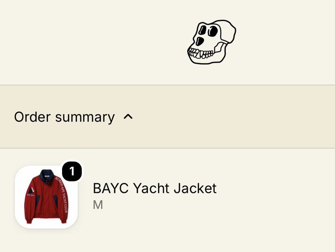An order summary page displaying a red 'BAYC Yacht Jacket' in size M, accompanied by a black and white cartoon skull logo at the top.