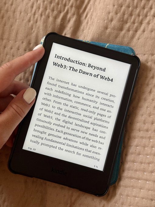 A hand holding a Kindle e-reader displaying chapter 3 (page 33) of a book titled 'Introduction: Beyond Web3: The Dawn of Web4', discussing the evolution from Web1 through Web3.