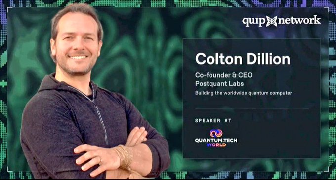 The image features a man standing with his arms crossed against a green background. The text on the image reads "Colton Dillard Co-Founder & CEO at Quantum Labs, speaking at Quip Network's Quantum Tech World Boston". This suggests that Colton Dillard is sharing insights and knowledge about QuantumTech during an event held by Quip Network in Boston.