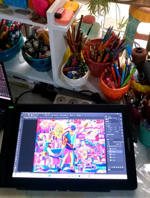 A workspace showing a digital drawing tablet displaying a vibrant colorful illustration, surrounded by various art supplies including containers of colored pencils and markers on shelves.