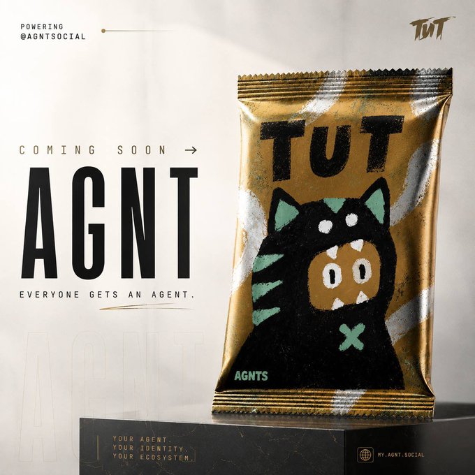 Promotional graphic for "AGNT" cryptocurrency token featuring a gold foil packaging design with a black cat character labeled "TUT," with text "COMING SOON," "EVERYONE GETS AN AGENT," and website "MY.AGNT.SOCIAL."