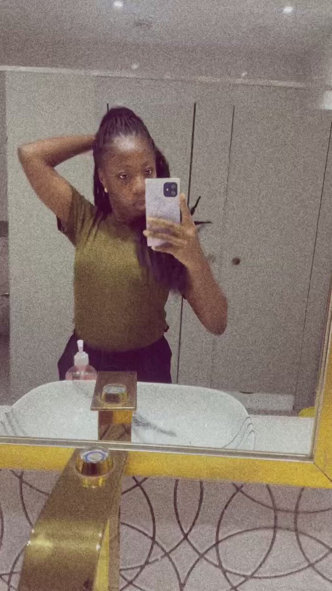 The image features a woman taking a selfie with her phone, standing in front of a bathroom mirror that has a gold frame around it. The background includes a sink and a countertop area. There are also two bottles visible in the scene - one on the left side of the photo and another closer to the center. The post seems to be related to the World Cup, as indicated by the text "good morning today is the kickoff for the World Cup are you excited? keep your eyes on $RIVER and predict is you can on its platform have an amazing day".