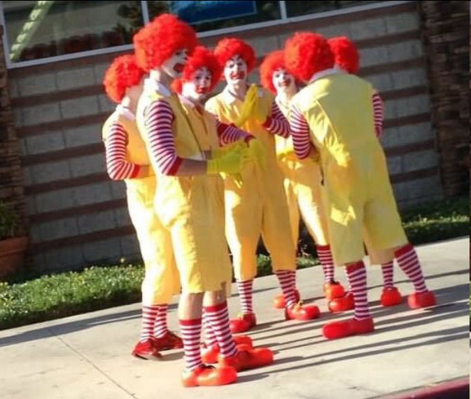 A group of people dressed as Ronald McDonald clowns huddle together on a sidewalk, visually embodying the post's warning about "clowns" who may be untrustworthy or hiding ulterior motives. The image serves as a literal representation of the figurative "clowns" the poster is warning others to beware of.