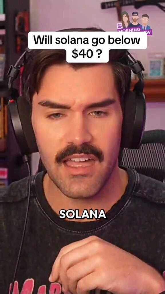 The image features a man wearing headphones, with his face partially visible behind them. He has a mustache and is dressed in a black shirt. The caption of the image reads "SOLANA GO BELOW $40?". This suggests that there might be an ongoing discussion or debate about the price of the product being advertised for sale on social media platforms like Instagram.

The man's facial expression appears to convey surprise, as if he has just heard something unexpected or surprising related to the product being advertised. The image captures a moment where the man is actively engaging with the content by reacting to it in real-time.