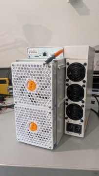 The image shows a customized Antminer S19-95T Bitcoin mining rig with two hashboards featuring white "White Out" cooling shrouds with orange "B" stickers, three visible cooling fans, and an LCD display reading "29.13". This physical crypto mining hardware directly illustrates the post offering a modded 120V S19-95T model for sale to buyers now flush with fiat currency.