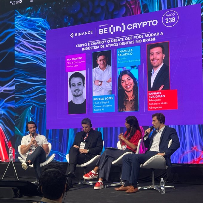 A panel discussion at a Binance-sponsored "BE [in] CRYPTO" event at PAICo 23B, featuring Yan Martins, Rocelo Lopes, Thamilla Talarico, and Raphael Cvaigman discussing digital assets in Brazil.