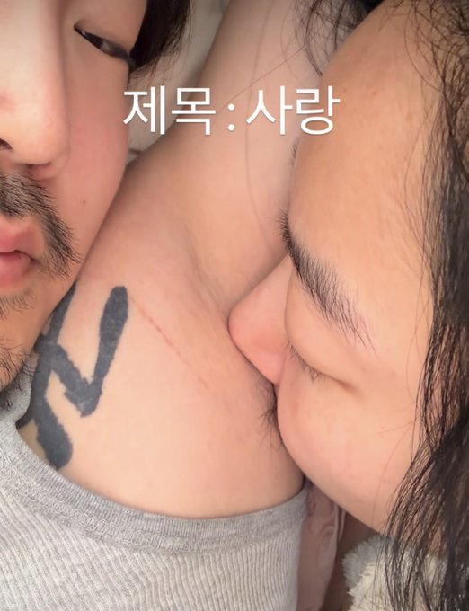 The image shows an intimate close-up of two people, with one person's tongue licking the other's neck, which bears a fresh "Love Cut" wound and a black tattoo. The Korean text "제목: 사랑" (Title: Love) overlays the photo, fittingly matching the post's theme about the "insanely high" trend of love bites/cuts.