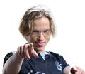 A young man with curly blonde hair and glasses wearing a plaid shirt, pointing forward with a serious expression.