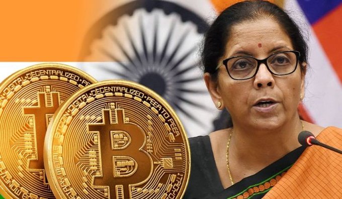 Indian Finance Minister Nirmala Sitharaman speaks at a press conference with physical Bitcoin tokens displayed in the foreground, illustrating the government's ongoing push for RBI and SEBI to regulate cryptocurrencies—a proposal both agencies continue to resist.