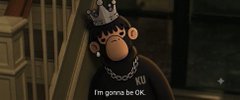 A small brown monkey wearing a black studded cap and a chain necklace looks up, with the subtitle 'I'm gonna be OK.' displayed below.