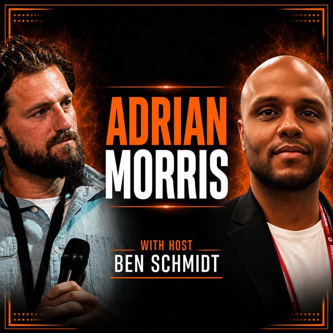 A podcast or interview thumbnail featuring two men with the name 'ADRIAN MORRIS' prominently displayed in large text, credited 'WITH HOST BEN SCHMIDT,' set against a dark textured background with orange accent borders.