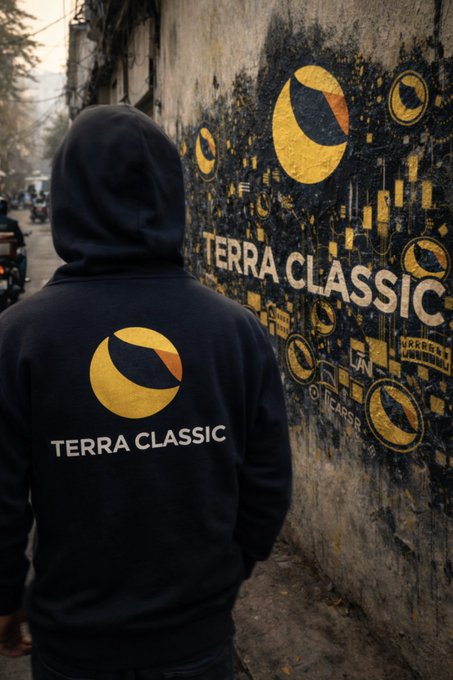 A person wearing a black hoodie with "TERRA CLASSIC" and its yellow crescent logo walks past a graffiti-covered wall featuring matching "TERRA CLASSIC" street art. The image reinforces the post's enthusiasm for $LUNC and $USTC as potential catalysts to revive an unexciting crypto market.